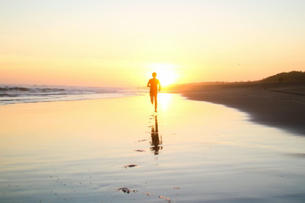 boy running into sunset