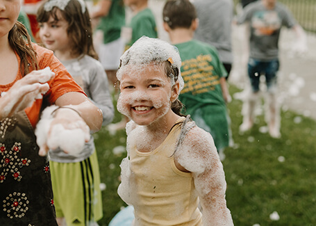 Girl playing with soap foam at VBS